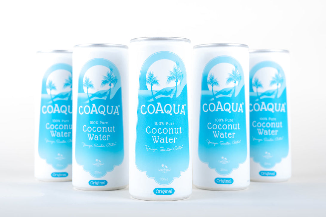 Five cans of COAQUA coconut water on a white background